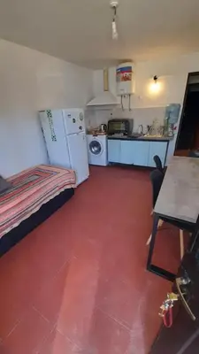 a small kitchen with a refrigerator and a stove at Departamento en cosquin in Cosquín