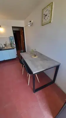a table with two chairs and a clock on the wall at Departamento en cosquin in Cosquín