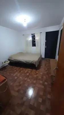 a bedroom with a bed and a wooden floor at Departamento en cosquin in Cosquín