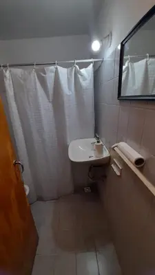 a white bathroom with a sink and a mirror at Departamento en cosquin in Cosquín
