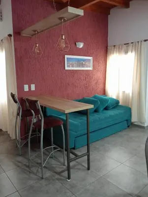 a dining room with a table and a couch at Cabañas La casita de las sierras in Barrio Parque El Corcovado
