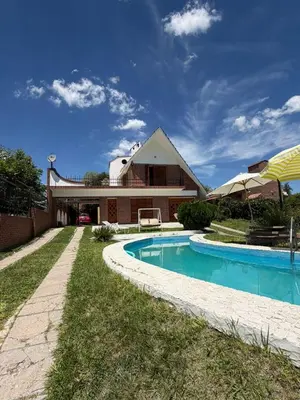 a house with a swimming pool in the yard at Chalet con Piscina, a 100 m del Río, Familias in Villa Carlos Paz