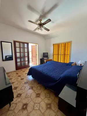 a bedroom with a blue bed and a ceiling fan at Chalet con Piscina, a 100 m del Río, Familias in Villa Carlos Paz