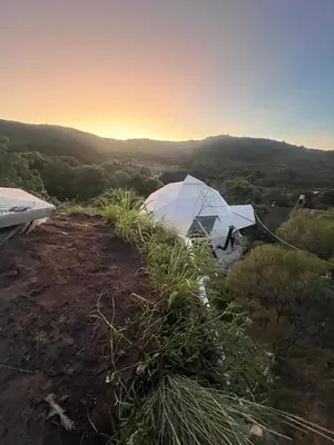 a white tent on top of a hill with the sunset at Goodkarma in Tanti