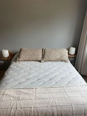 a bed in a bedroom with two nightstands and two lamps at Cabañas Arenas del Panaholma in Villa Cura Brochero
