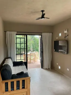 a bedroom with a bed and a ceiling fan at Cabañas Arenas del Panaholma in Villa Cura Brochero