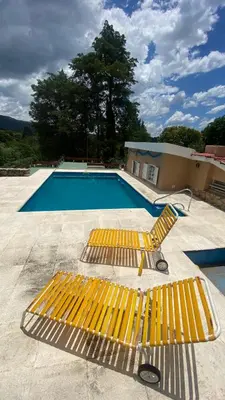 a yellow bench sitting next to a swimming pool at La Matera, San Clemente, Córdoba in San Clemente