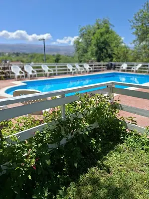 a fence next to a swimming pool with chairs at Lo de coco in Villa Cura Brochero