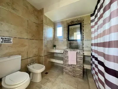 a bathroom with a toilet and a sink at Lo de coco in Villa Cura Brochero