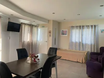 a living room with a dining table and a bedroom at Lo de coco in Villa Cura Brochero