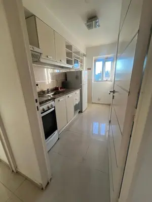 a kitchen with white cabinets and a stove at Departamento en complejo residencial entero en Córdoba, Argentina in Cordoba