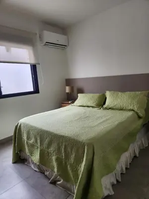 a bedroom with a green bed with a window at Departamento macrocentro I, espacioso Río Cuarto in Río Cuarto