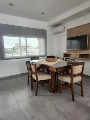 a dining room with a table and chairs and a television at Departamento macrocentro I, espacioso Río Cuarto in Río Cuarto