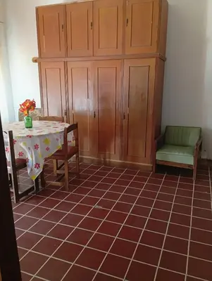 a room with a table and a chair and a cabinet at Departamento Temporario y Complejo Habitacional in Villa Carlos Paz