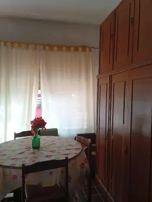 a dining room table with a vase of flowers on it at Departamento Temporario y Complejo Habitacional in Villa Carlos Paz