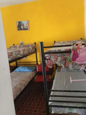a room with three bunk beds and a yellow wall at Departamento Temporario y Complejo Habitacional in Villa Carlos Paz