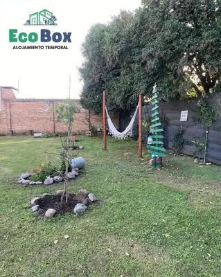 a garden with a tree and a hammock at EcoBox in Despeñaderos