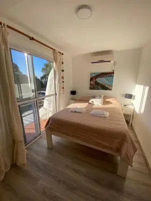 a bedroom with a large bed and a balcony at EcoBox in Despeñaderos