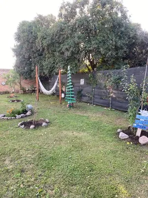 a yard with a fence and a garden with a tree at EcoBox in Despeñaderos