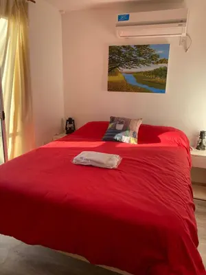 a bedroom with a red bed with a red blanket at EcoBox in Despeñaderos