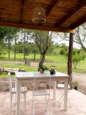 a white table and chairs on a patio at Cabaña La Querencia in Piedras Blancas