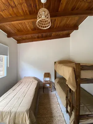 a bedroom with two beds and a wooden ceiling at Cabaña La Querencia in Piedras Blancas