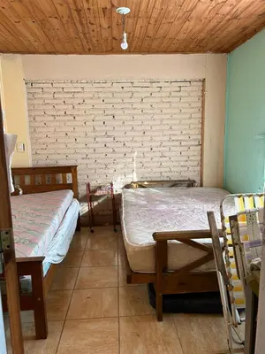 a room with two beds and a table in it at Casa Estancia in Villa Carlos Paz