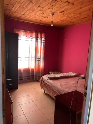 a bedroom with a bed and a red wall at Casa Estancia in Villa Carlos Paz