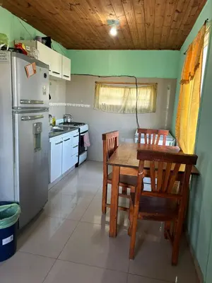 a kitchen with a table and chairs and a refrigerator at Casa Estancia in Villa Carlos Paz