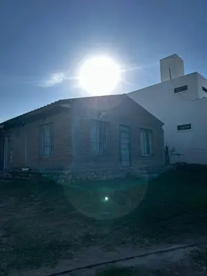 a house with the sun setting on top of it at Casa Estancia in Villa Carlos Paz