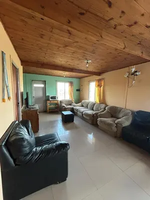 a living room with leather couches and a wooden ceiling at Casa Estancia in Villa Carlos Paz