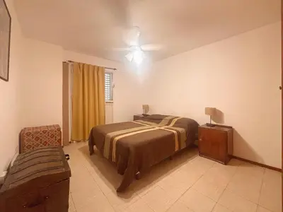 a bedroom with a bed and a table and a chair at Depto Victoria in Cordoba