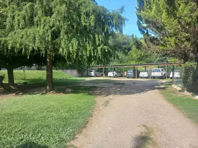a dirt road with a tree and parked cars at Tantanakuy 4 in Villa General Belgrano