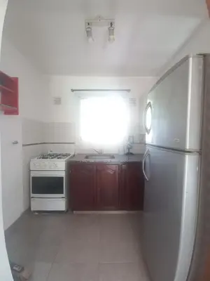 a kitchen with a refrigerator and a stove and a window at Tantanakuy 4 in Villa General Belgrano