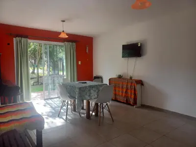 a dining room with a table and chairs and a television at Tantanakuy 4 in Villa General Belgrano