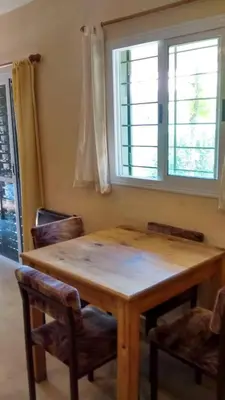 a wooden table and chairs in a room with a window at Casita del Lago in Villa Carlos Paz