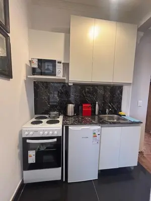 a kitchen with white cabinets and a stove and a sink at Apartment in the historic center in Cordoba