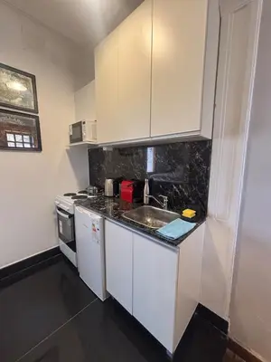 a small kitchen with white cabinets and a sink at Apartment in the historic center in Cordoba