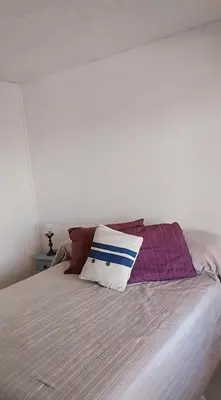 a bed with several pillows on top of it at Casa Pileta Playa Tanti - Cabalango in Tanti