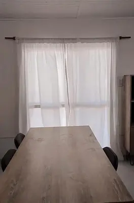 a large wooden table in front of a window at Casa Pileta Playa Tanti - Cabalango in Tanti