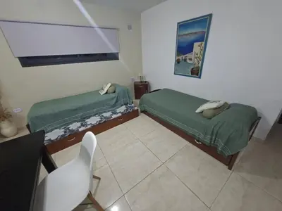 two beds in a room with a table and a chair at paraíso lomas in San Antonio de Arredondo