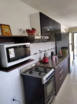 a kitchen with a stove and a microwave at paraíso lomas in San Antonio de Arredondo