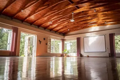 an empty living room with a wooden ceiling and a screen at Paraiso en el Manantial in Villa General Belgrano