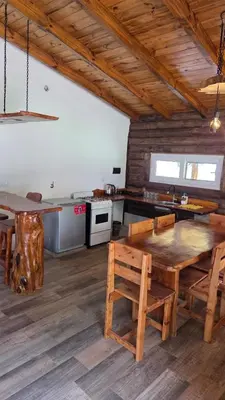a kitchen with a wooden table and a kitchen with a stove at Paraiso en el Manantial in Villa General Belgrano
