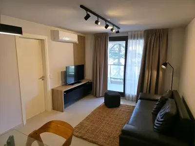 a living room with a black couch and a television at Opera Park en Barrio Las Rosas in Cordoba