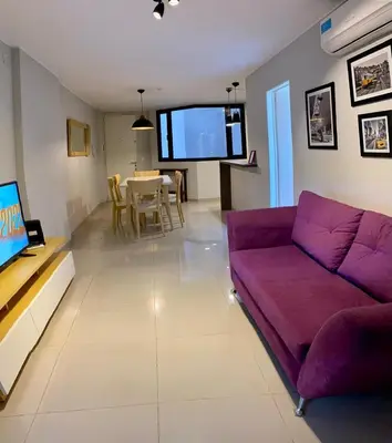 a living room with a purple couch and a table at NUEVA CORDOBA, Zona PLAZA ESPAÑA PARQUE SARMIENTO in Cordoba