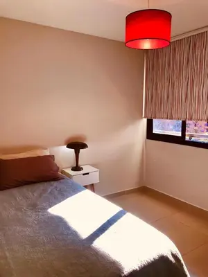 a bedroom with a bed and a red lamp at NUEVA CORDOBA, Zona PLAZA ESPAÑA PARQUE SARMIENTO in Cordoba