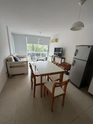 a living room with a table and chairs and a refrigerator at Depto Carillo 4p in Villa Carlos Paz