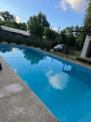 a swimming pool with blue water in a yard at Sami LLankay II in Villa Ciudad Parque