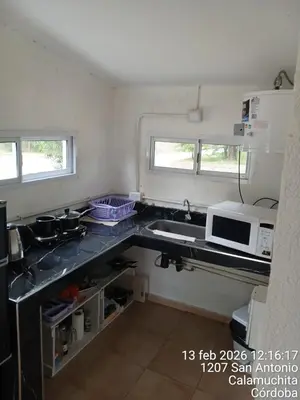 a small kitchen with a sink and a microwave at Sami LLankay II in Villa Ciudad Parque